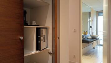 A modern bathroom with a large mirror, a sink, and a shower area.