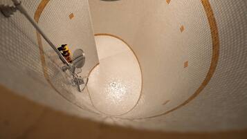 A close-up of a textured ceiling with a circular design and a central light fixture.