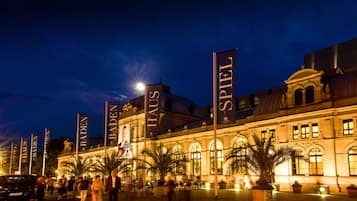 Ein historisches Gebäude mit großen Bannern, auf denen "BADEN HAUS" und "SPIEL" zu sehen sind, bei Nacht.