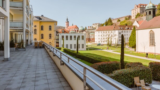 A balcony with a view of historic buildings, a well-maintained lawn, and a clear sky. - Aqua Aurelia Suitenhotel an den Thermen (Baden-Baden)