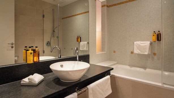 Une salle de bain moderne avec un grand lavabo, une baignoire et une douche.