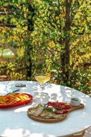 Un tavolo con un bicchiere di martini, un tagliere con cibo e un piatto rosso con patatine.