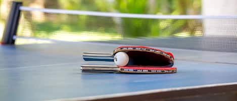 Et bordtennisbord med net, bat og bold.