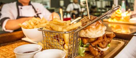 A meal tray with a burger, fries, and two dipping sauces.
