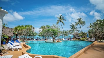 Una piscina al aire libre, sombrillas, sillones reclinables de piscina