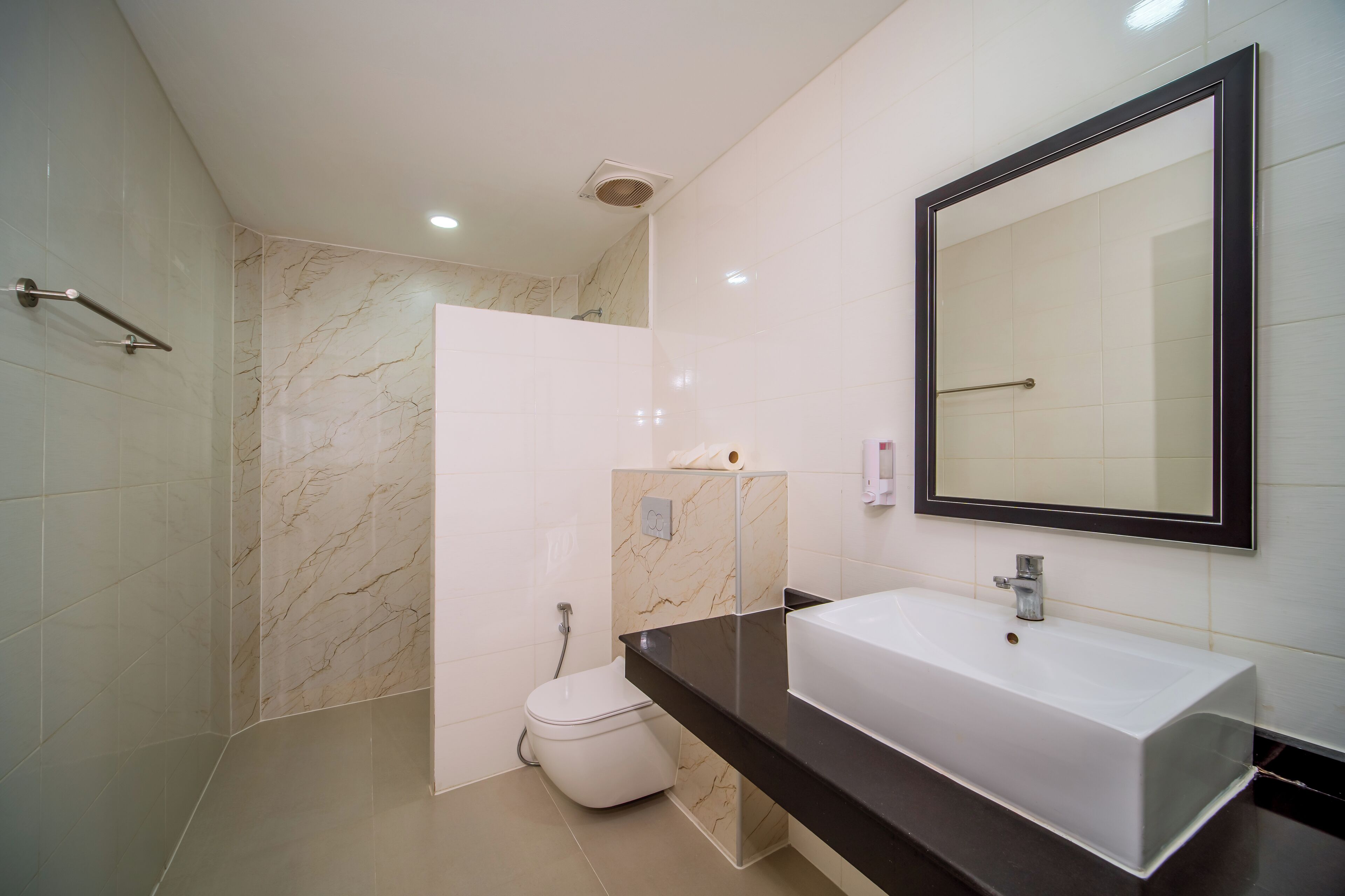 A modern bathroom with a white sink, a large mirror, and a shower area.