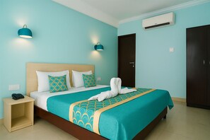 A hotel room with a bed, bedside table, wall-mounted air conditioning unit, and a wardrobe. - Hotel Eurostar International (New Delhi)