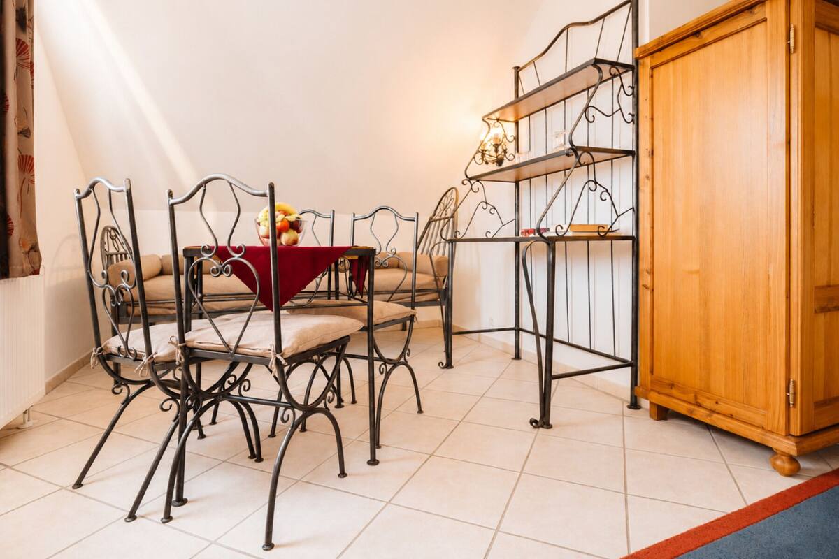 Un coin repas comprenant une table et des chaises, un buffet en bois et une étagère en métal.