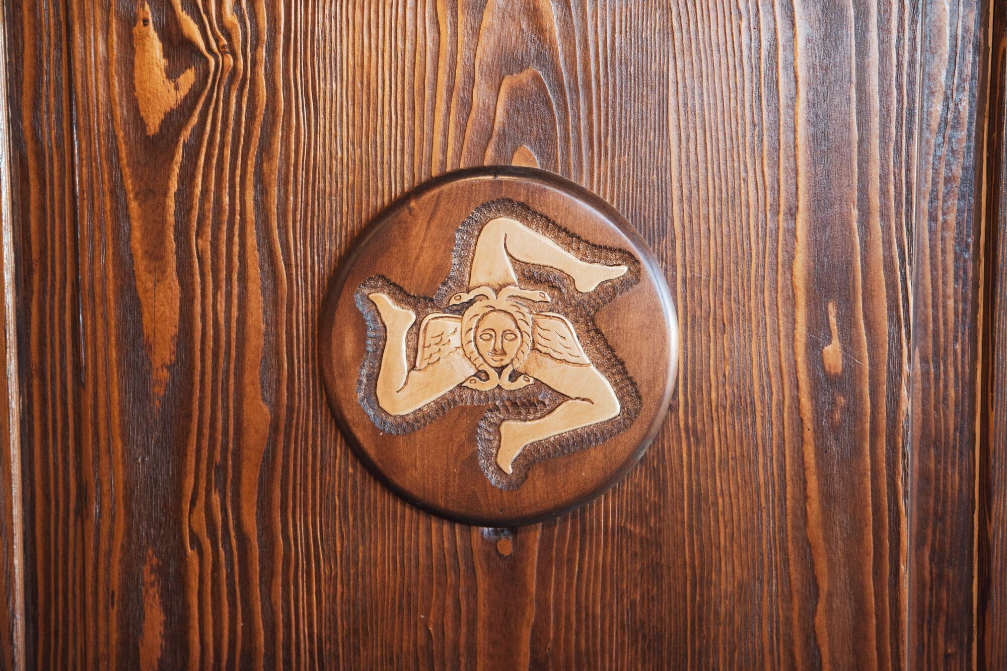 A wooden surface with a circular object featuring a carved design.