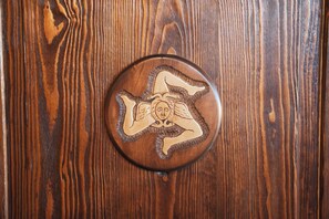 A wooden surface with a circular object featuring a carved design. - Agri Hotel da Marianna (Santa Domenica Vittoria)