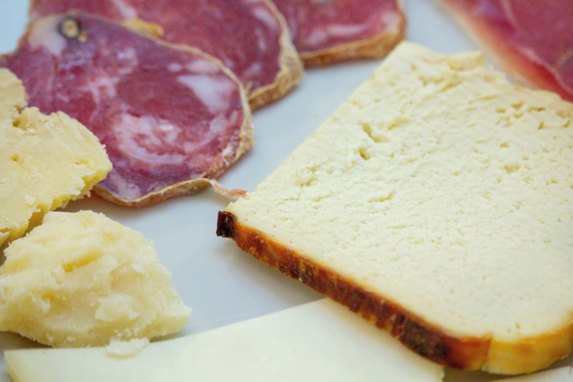 Rebanadas de queso y jamón en un plato.