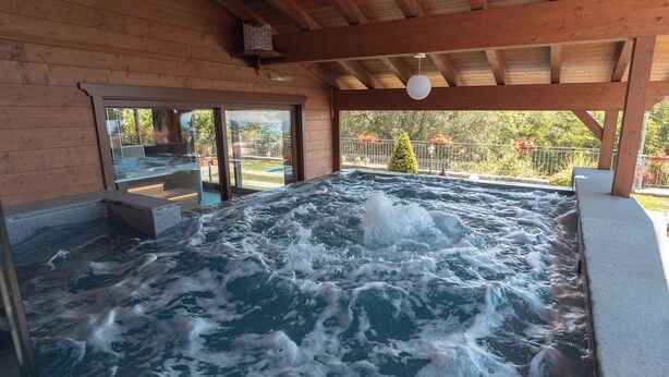 Een hottub met een houten binnenkant en uitzicht op de omgeving.