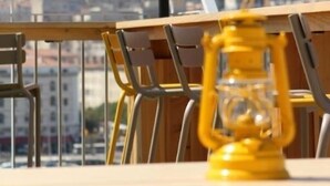 Un balcón con vista a un paisaje urbano, incluyendo una colina con un edificio.