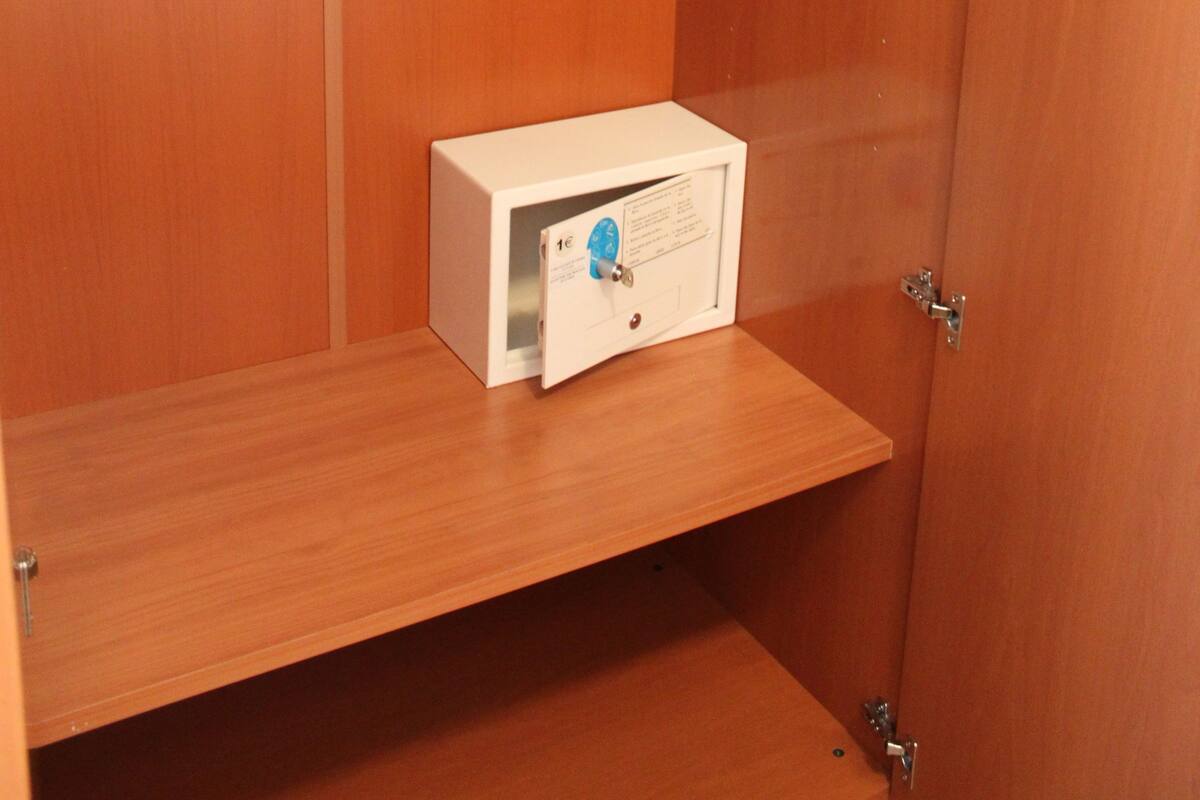A wooden wardrobe with a hanging rack and a small shelf.
