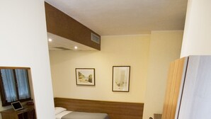 A hotel room with two beds, a desk with a laptop, and two framed pictures on the wall. - Europa (Sondrio)