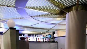 A modern reception desk with a curved design, a glass partition, and a decorative column. - Europa (Sondrio)