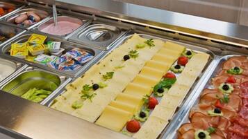 A buffet with various food options including meats, cheeses, and vegetables.