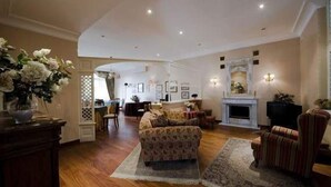A spacious living room with a sofa, armchairs, and a fireplace. - Hotel La Culla del Lago (Castel Gandolfo)