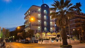 A multi-story hotel with balconies, a sign indicating it is a 4-star establishment, and a palm tree in the foreground. - Ambassador (Tortoreto)