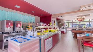 A modern breakfast buffet with a variety of food options, a coffee station, and a seating area with a view.