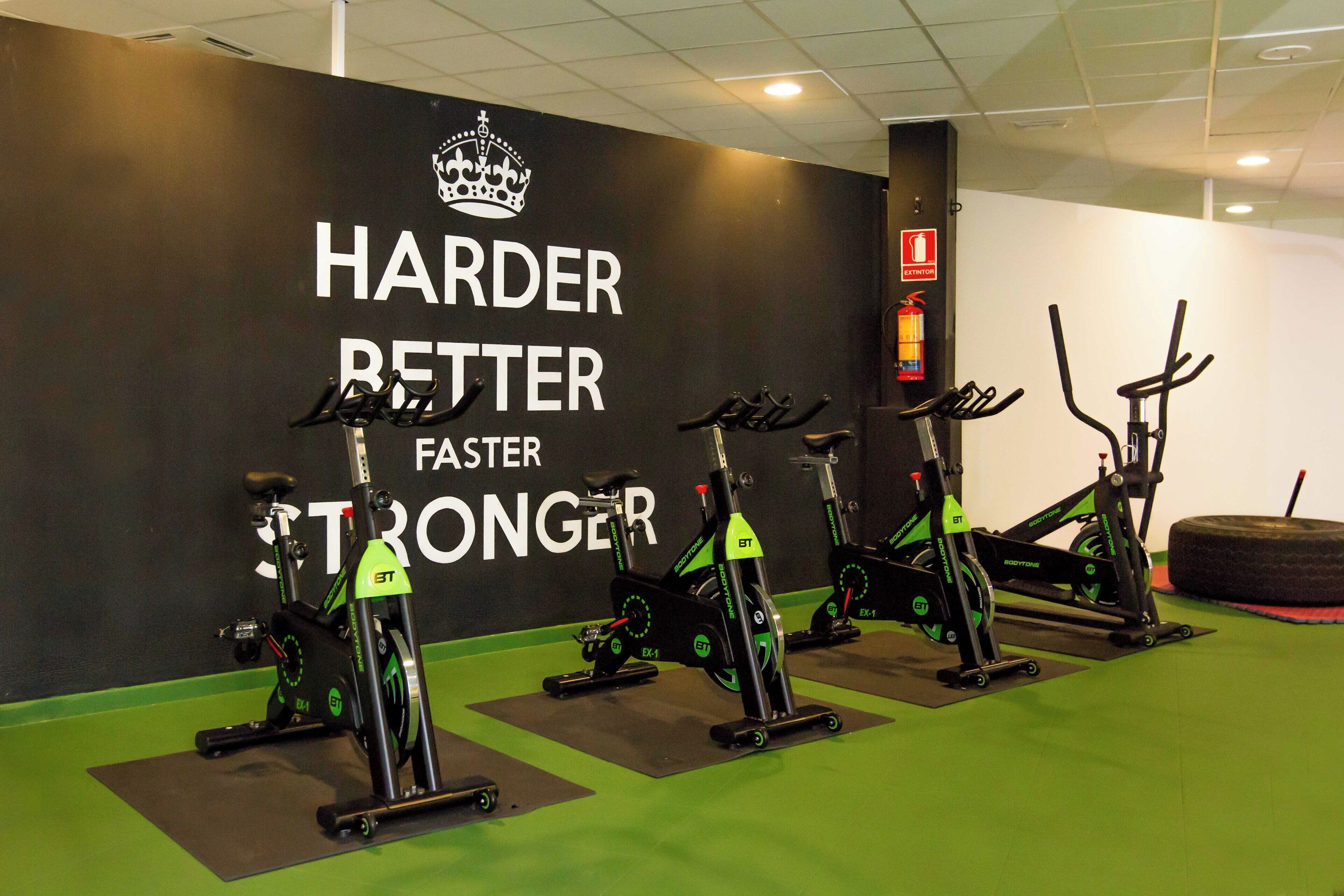 A gym with stationary bikes and a motivational wall.