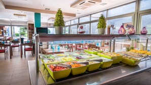 Een buffetgedeelte met diverse etenswaren en potplanten.