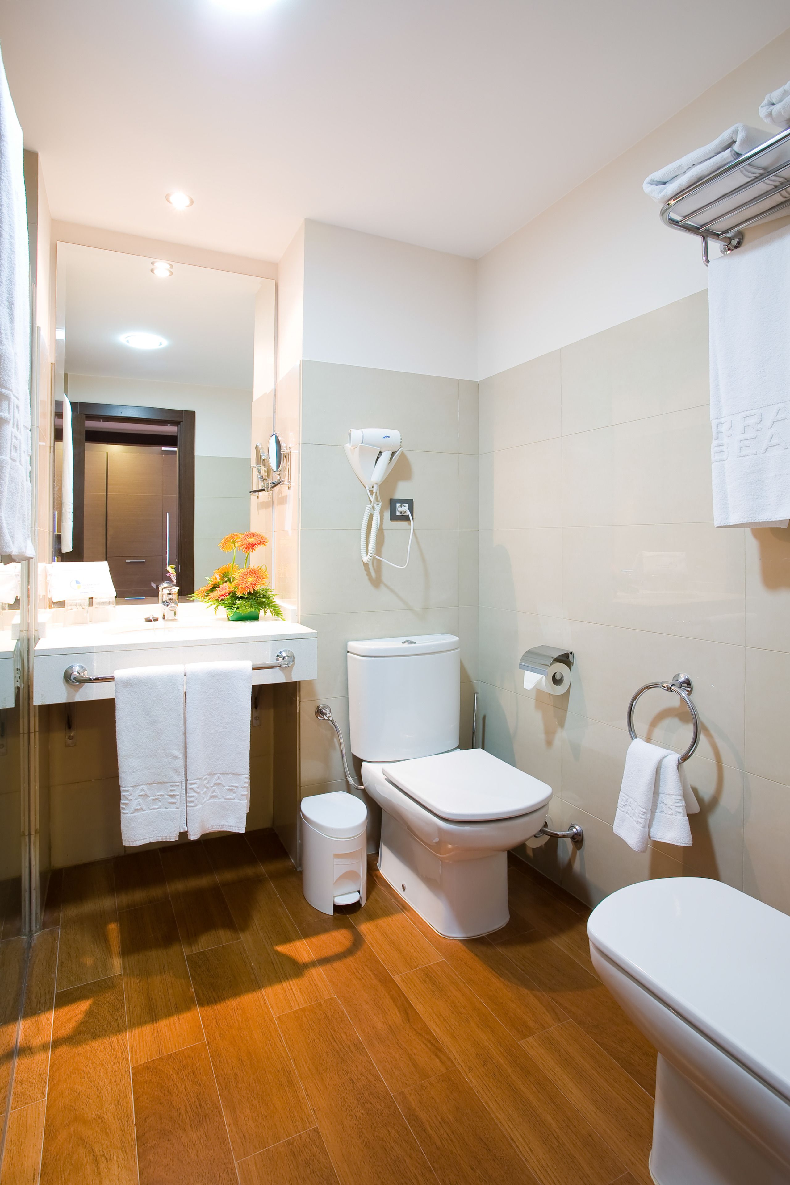Een moderne badkamer met toilet, wastafel en douche.