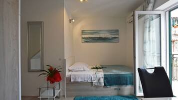 Cozy retreat with a single bed, painting, and window offering a view.