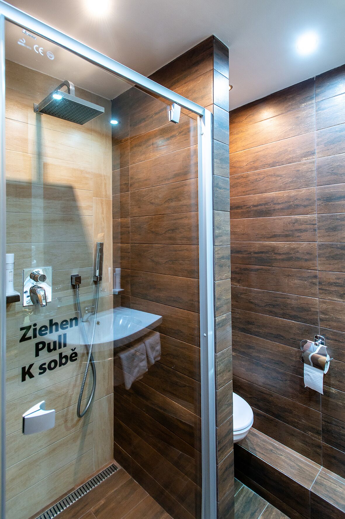 Un baño moderno con cabina de ducha de vidrio, lavamanos e inodoro.