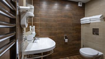 Ein modernes Badezimmer mit integriertem Waschbecken, Toilette und Handtuchhalter.