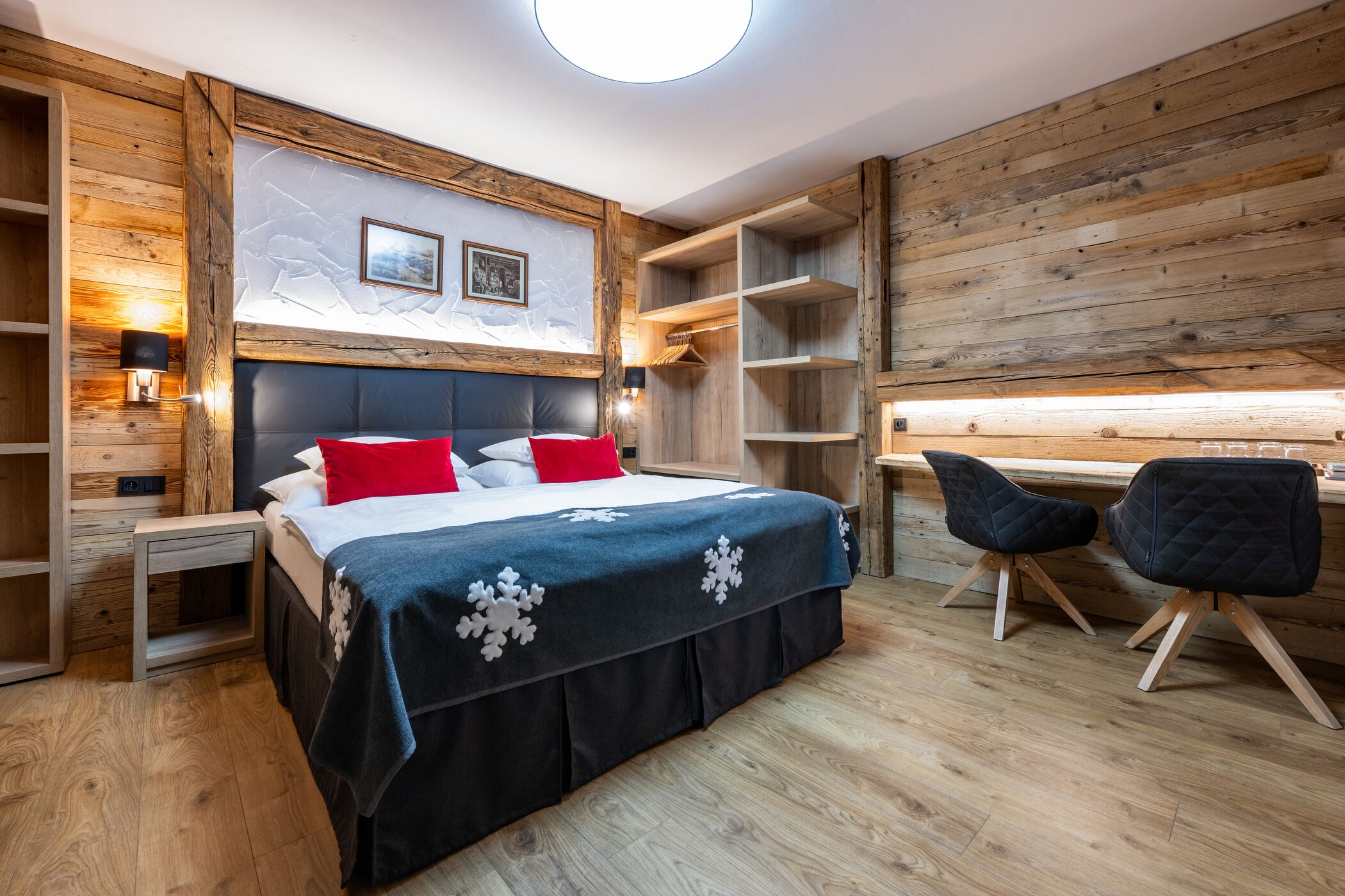 Ein Schlafzimmer mit einem großen Bett, Holzwänden und einem Oberlicht.