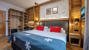 A bedroom with a large bed, wooden walls, a built-in wardrobe, and a nightstand with a lamp.
