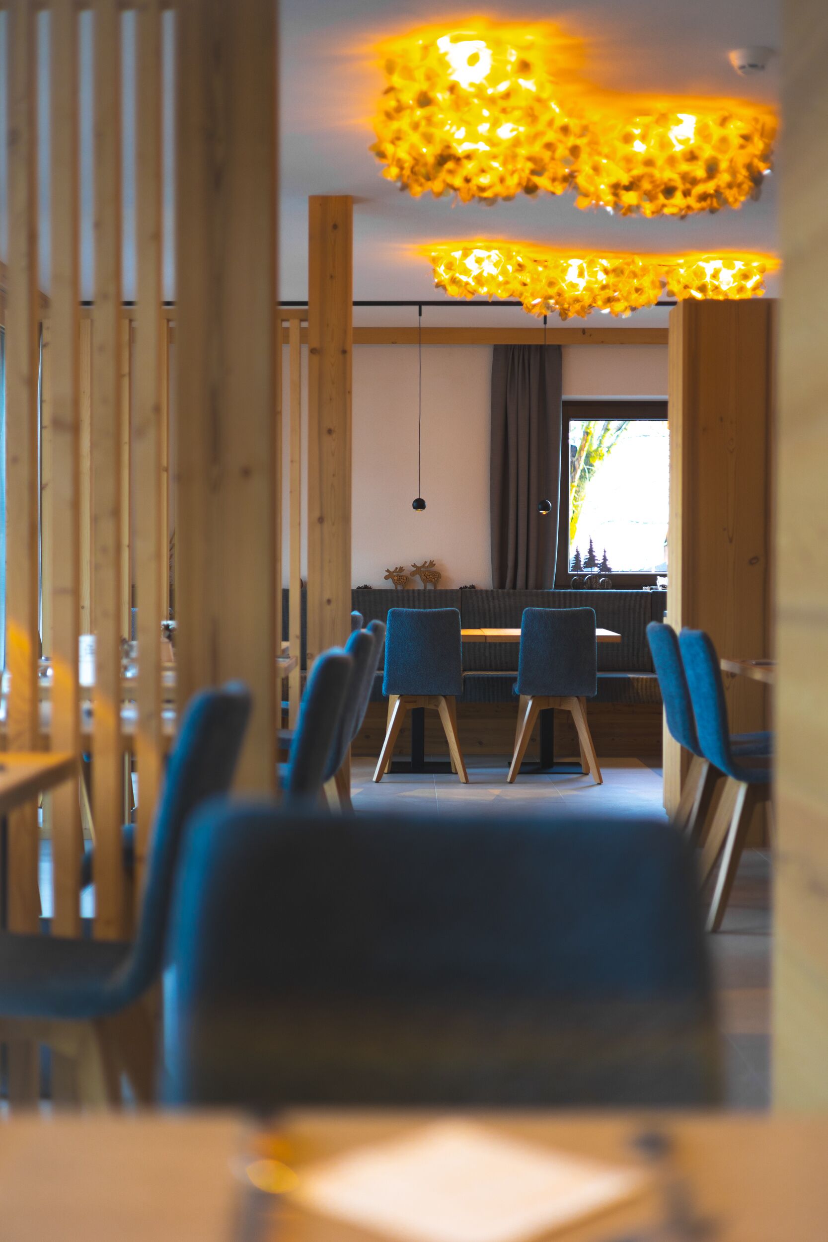 Een moderne eetruimte met houten meubels en een bijzondere plafondlamp.