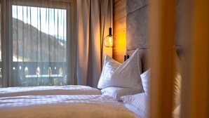 Une chambre d’hôtel avec un lit, des oreillers, une table de chevet et une lampe.