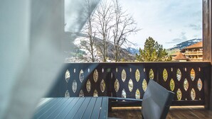 Une terrasse en bois offrant une vue sur les montagnes et un bâtiment en arrière-plan.