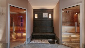 Un intérieur moderne avec un mur en briques noires, deux panneaux éclairés et un banc en bois.