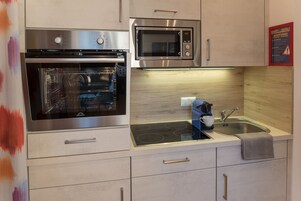 A modern kitchen with a built-in oven, microwave, and a sink with a faucet.