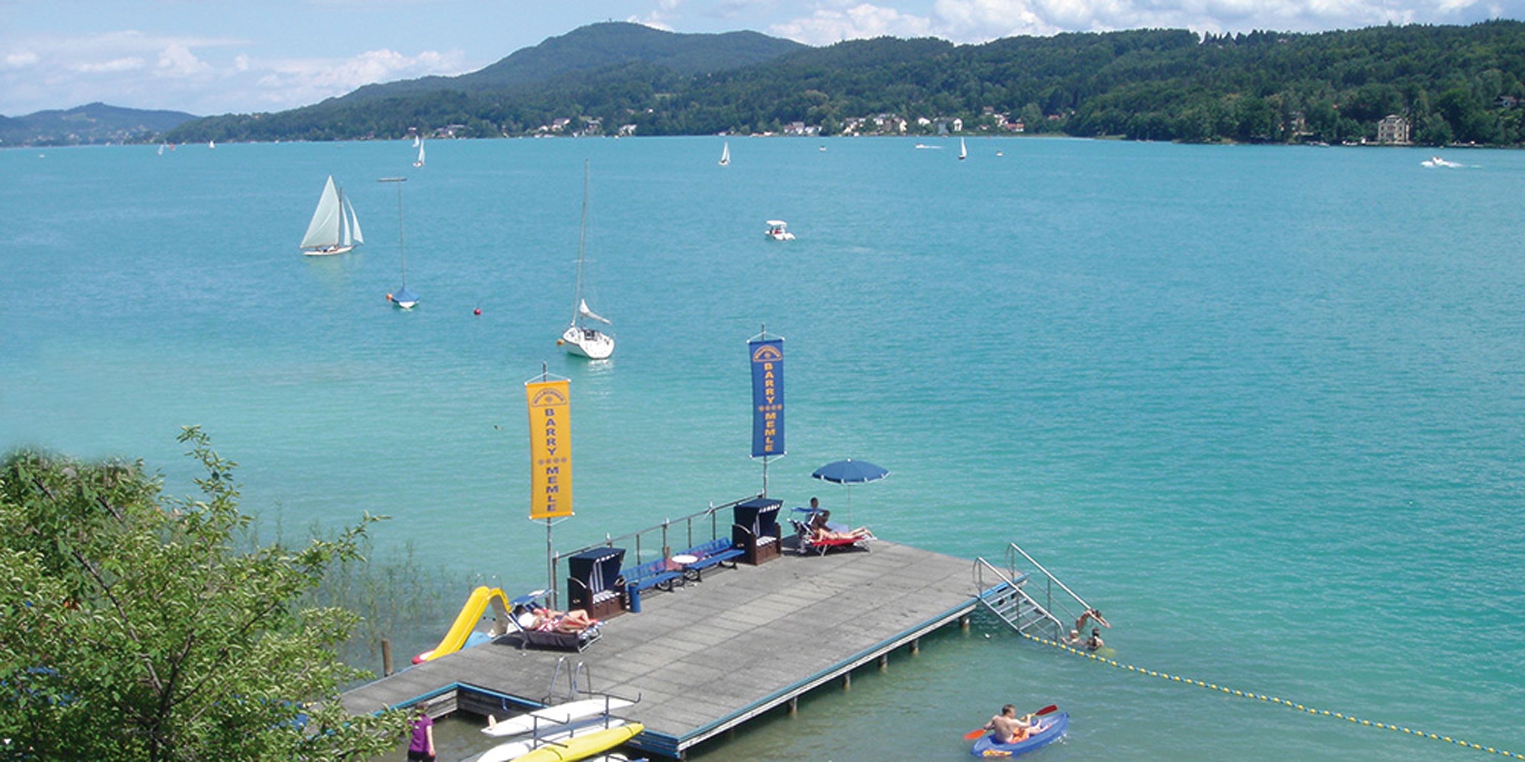 A pier with a dock, a lifeguard tower, and a flag.
