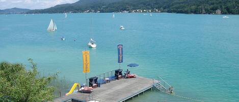 A pier with a dock, a lifeguard tower, and a flag.