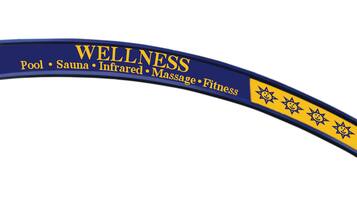 Ein gebogenes Schild mit dem Wort "WELLNESS" und aufgeführten Leistungen: Schwimmbad, Sauna, Infrarot, Massage, Fitness.