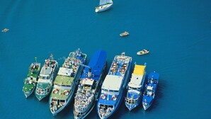 Un grand navire de croisière était amarré, et plusieurs petits bateaux se trouvaient à proximité.