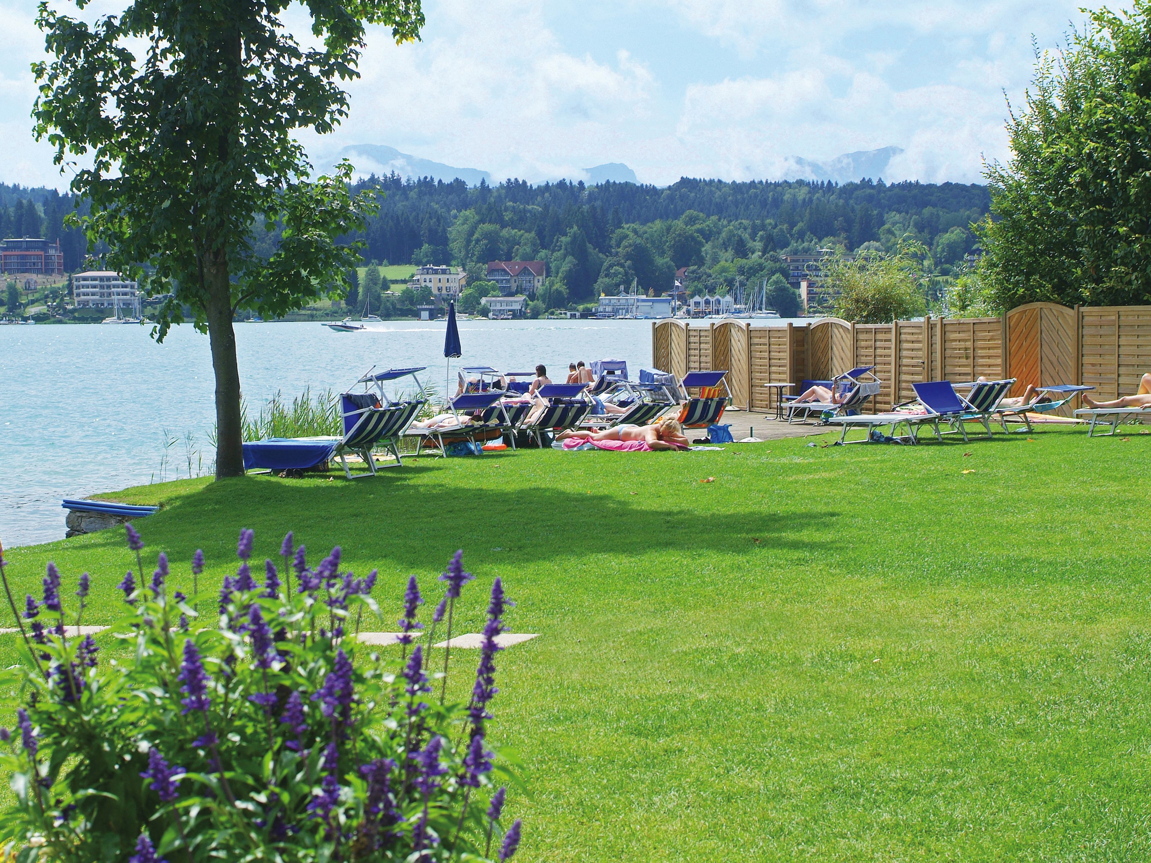Une vue sur le lac, avec des chaises longues et une terrasse en bois.