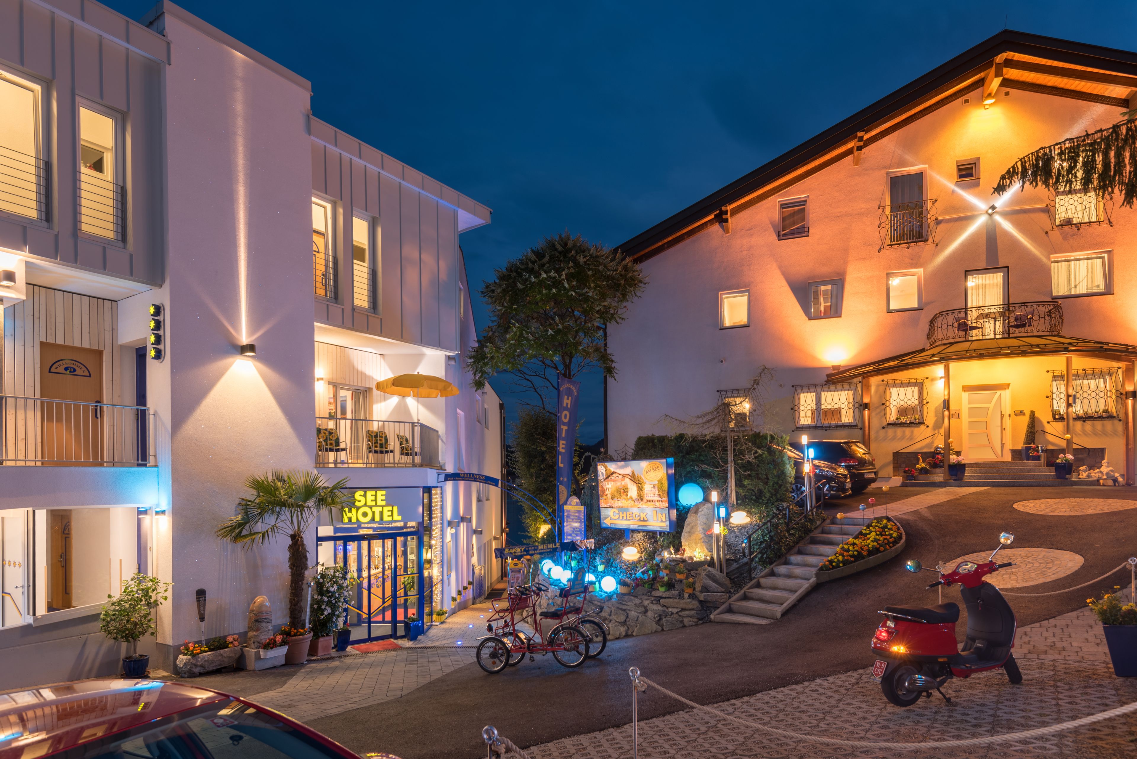 Un hotel amb una entrada ben visible, una bicicleta aparcada a fora i un patinet davan.