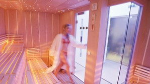 Un sauna équipé de bancs et d’une porte.