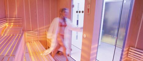 A sauna room with benches and a door.