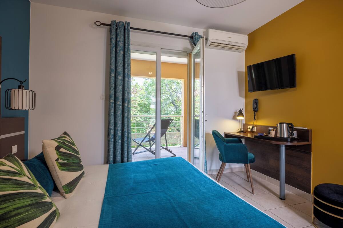 Een hotelkamer met een bed, bureau, stoel en televisie.