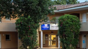 A hotel entrance with a sign for "The Originals" and "Hotel Cote Sud".