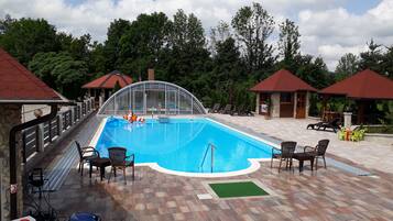 Relax by the pool surrounded by lush greenery and comfortable seating options.
