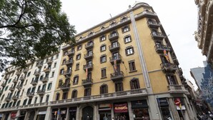 Un immeuble à plusieurs étages doté de balcons, d’une entrée au niveau du sol et d’une devanture visible.