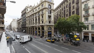 Una calle urbana concurrida con edificios históricos, un taxi y un camión de reparto.